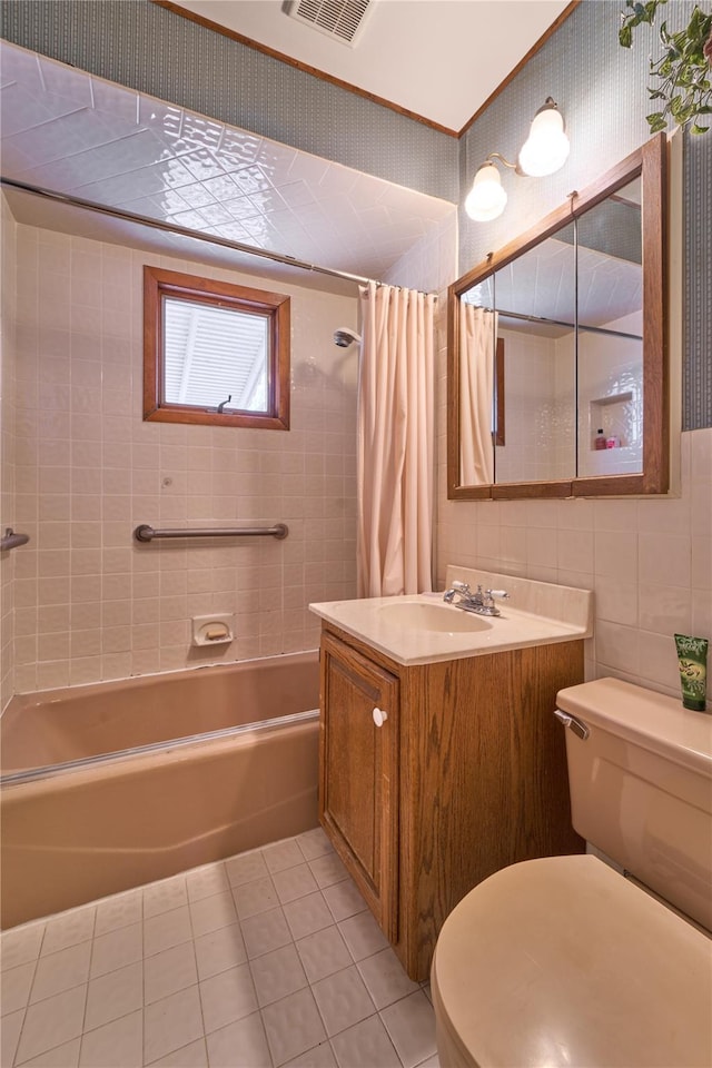 full bathroom with shower / tub combo with curtain, tile walls, vanity, toilet, and tile patterned floors