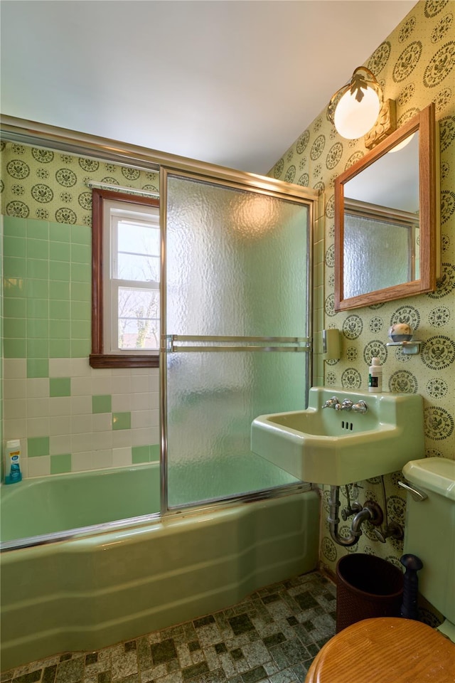 bathroom featuring shower / bath combination with glass door and toilet