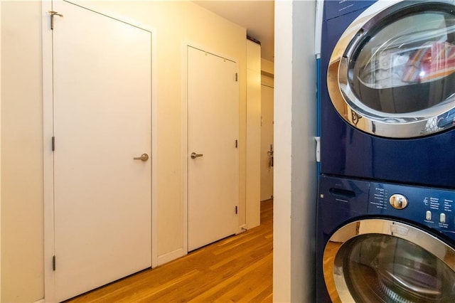 washroom with stacked washer and clothes dryer and light hardwood / wood-style floors