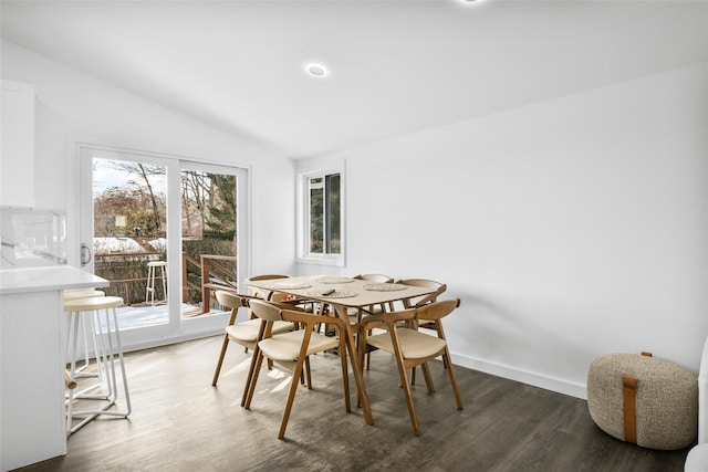 dining area featuring lofted ceiling and dark wood-type flooring