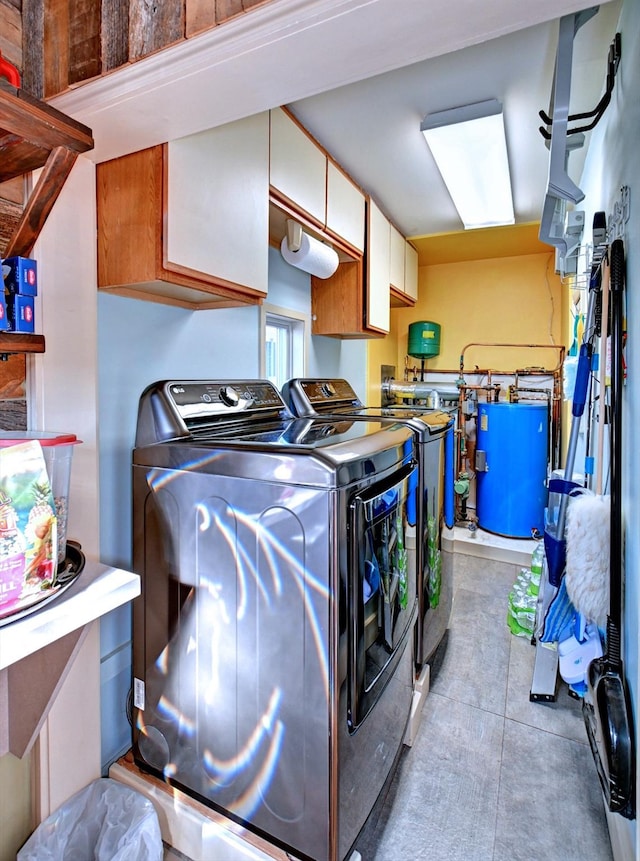 washroom with cabinets, light tile patterned floors, and washer and clothes dryer