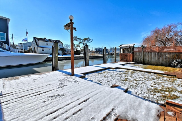 yard covered in snow featuring a water view