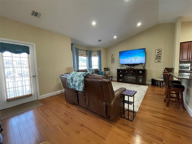 living room featuring vaulted ceiling and light hardwood / wood-style floors