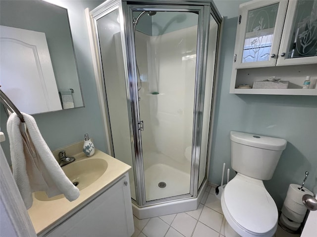 bathroom featuring tile patterned floors, vanity, toilet, and an enclosed shower