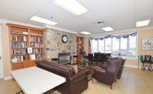 living room with crown molding, a paneled ceiling, and a fireplace