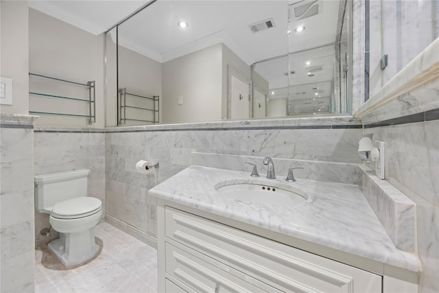 bathroom with tile walls, vanity, ornamental molding, and toilet