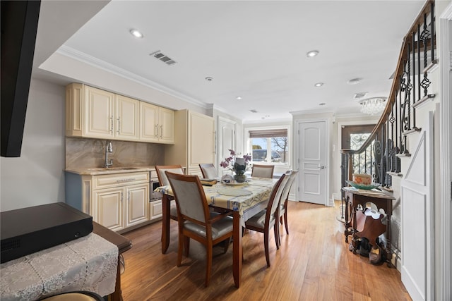 dining room featuring crown molding, light hardwood / wood-style floors, and sink