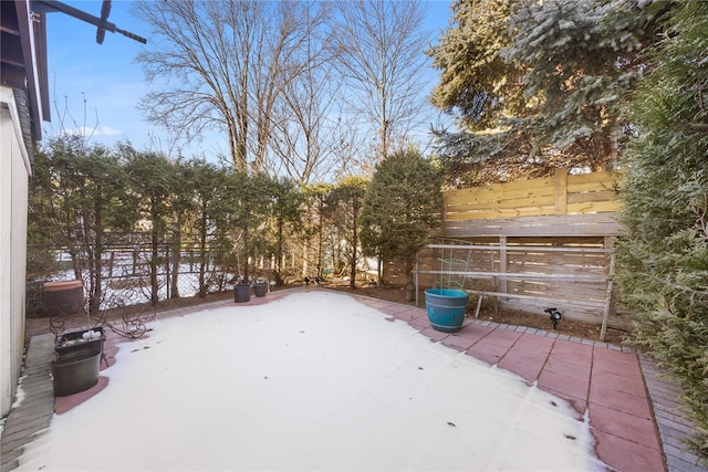 snowy yard featuring a patio area