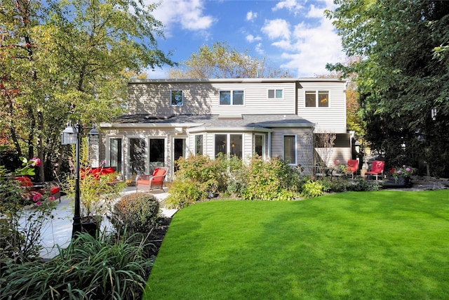 back of property with a yard and a patio area