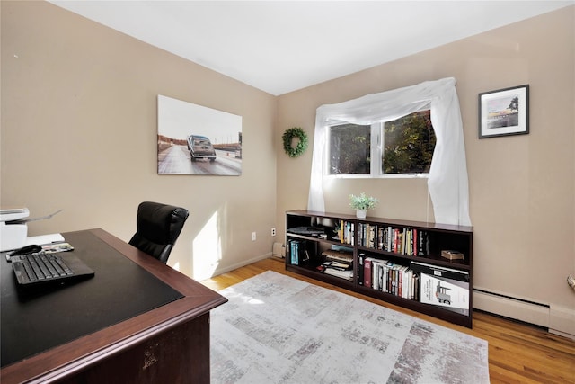 office area with light hardwood / wood-style flooring and a baseboard heating unit