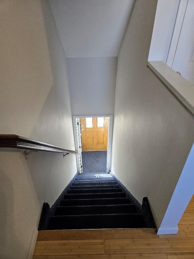 stairs featuring wood-type flooring and a high ceiling