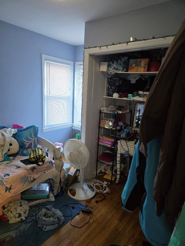 bedroom with hardwood / wood-style flooring and radiator