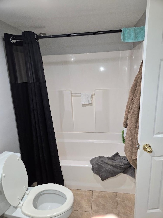 bathroom with shower / tub combo with curtain, tile patterned floors, and toilet