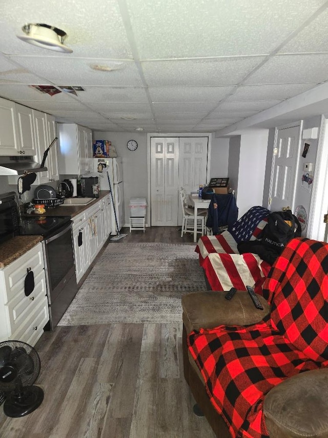 living room featuring dark hardwood / wood-style flooring, sink, and a paneled ceiling