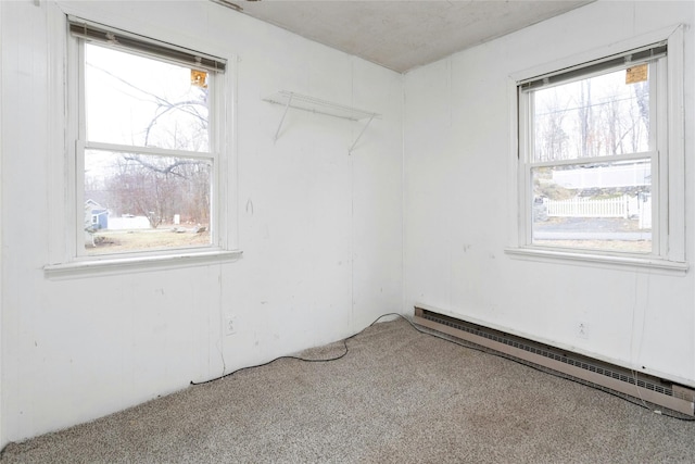 carpeted spare room with a baseboard heating unit and plenty of natural light