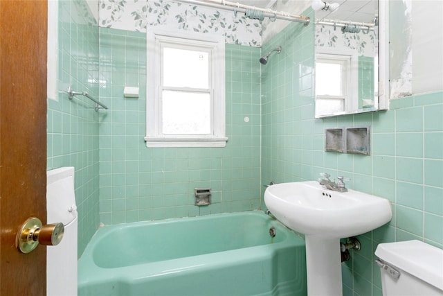 bathroom with tile walls, plenty of natural light, and toilet