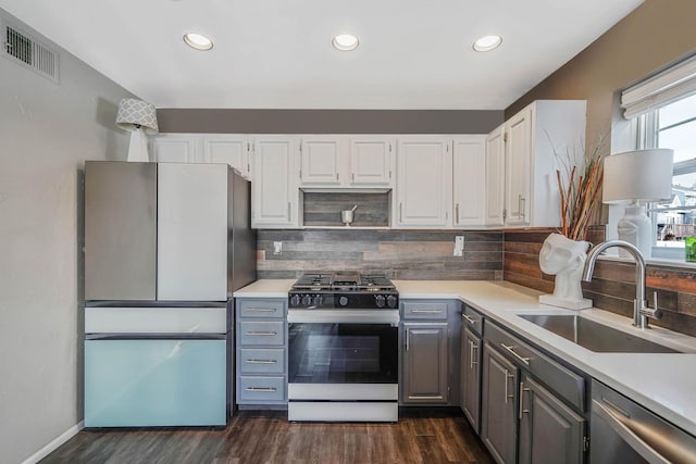 kitchen featuring sink, fridge, white cabinets, decorative backsplash, and range with gas cooktop