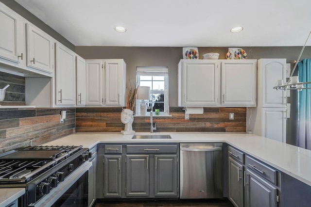 kitchen with stainless steel appliances, tasteful backsplash, sink, and white cabinets