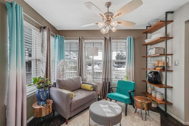 living area with wood-type flooring and ceiling fan