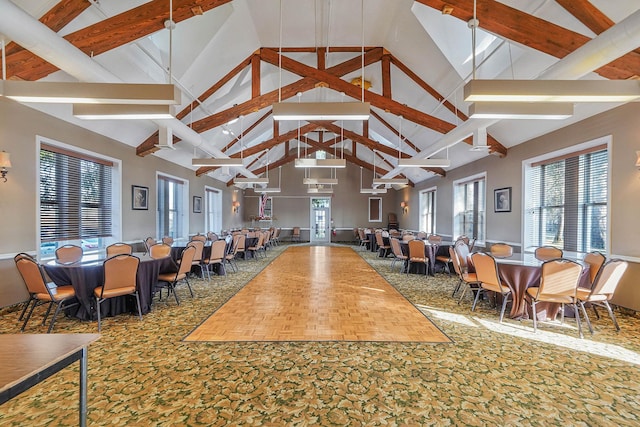 dining space with beamed ceiling, carpet flooring, and high vaulted ceiling