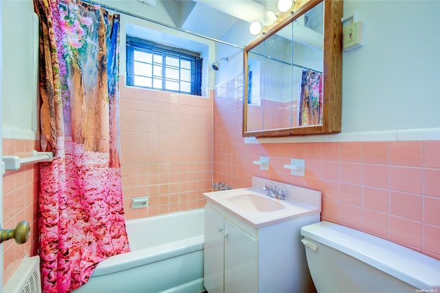 full bathroom with vanity, toilet, shower / bath combo with shower curtain, and tile walls