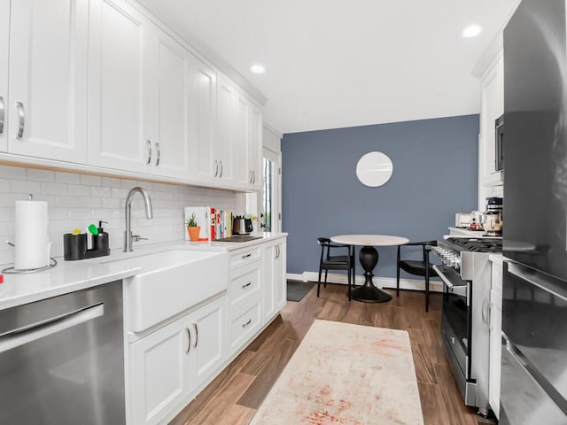 kitchen featuring stainless steel appliances, white cabinetry, sink, and dark wood-type flooring