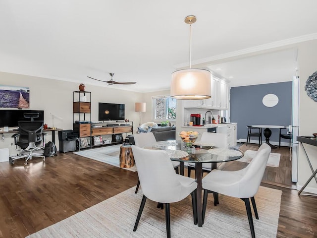 dining room with wood-type flooring, sink, crown molding, and ceiling fan