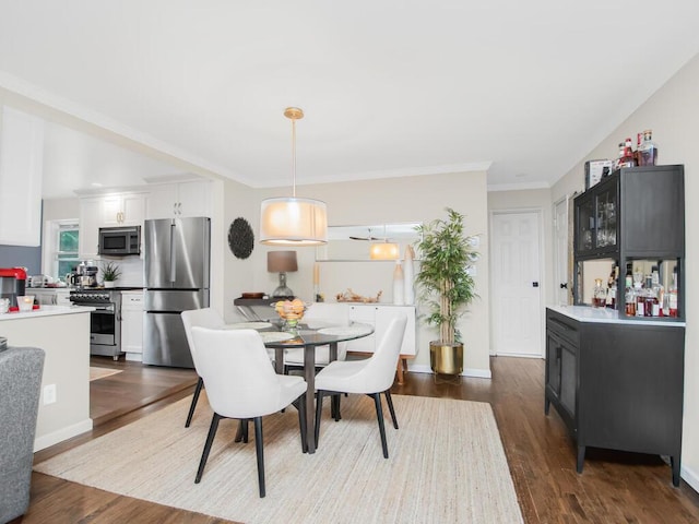 dining area featuring hardwood / wood-style floors and crown molding