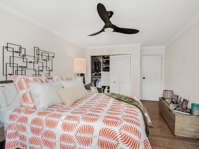 bedroom featuring hardwood / wood-style flooring, ornamental molding, ceiling fan, and a closet