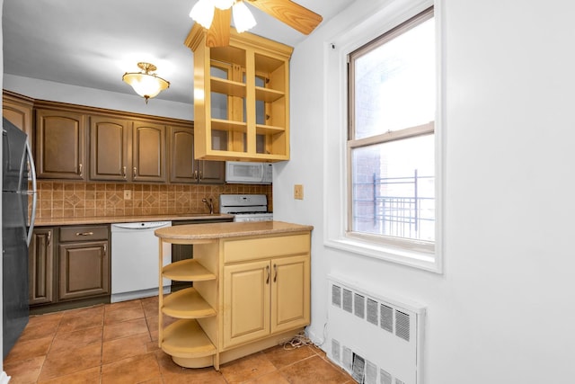 kitchen featuring sink, radiator, white appliances, ceiling fan, and decorative backsplash