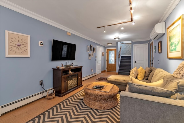 living room with crown molding, a baseboard heating unit, a wall mounted air conditioner, and rail lighting