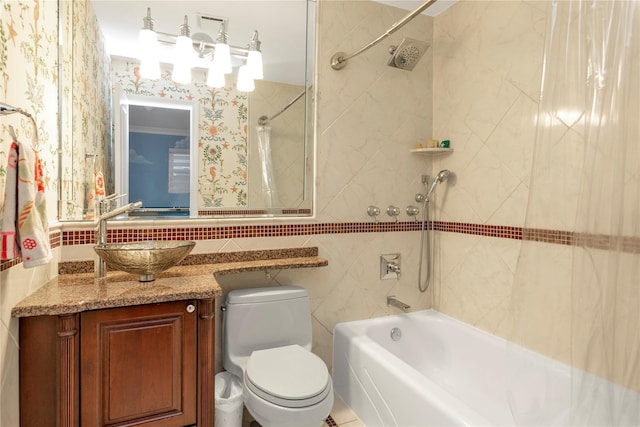 full bathroom featuring vanity, tiled shower / bath, and toilet