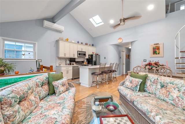 living room with a skylight, high vaulted ceiling, light hardwood / wood-style flooring, a wall unit AC, and ceiling fan