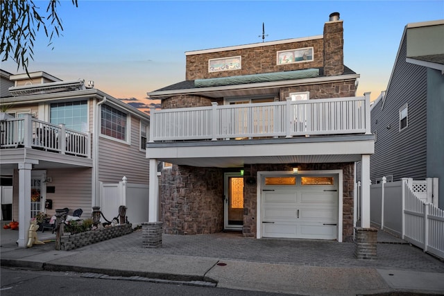 view of front facade featuring a garage and a balcony