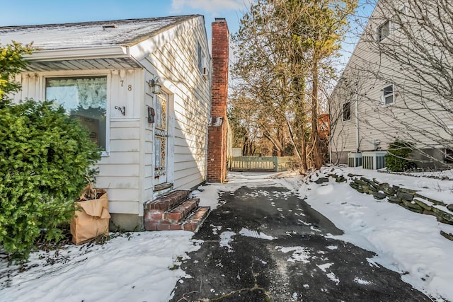 view of snowy exterior featuring central AC