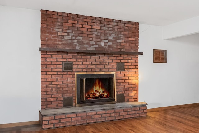 interior details with wood-type flooring and a fireplace