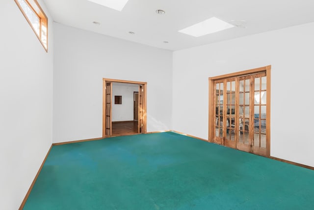 carpeted empty room featuring a skylight