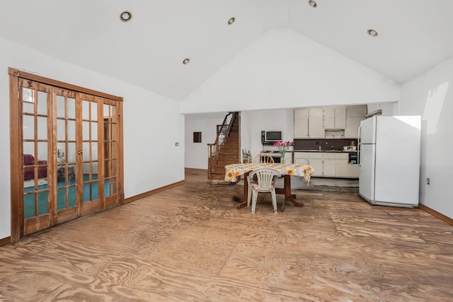 kitchen with white cabinetry, high vaulted ceiling, and white fridge