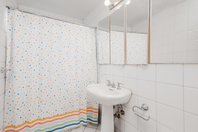 bathroom featuring tile patterned flooring, tile walls, backsplash, and walk in shower