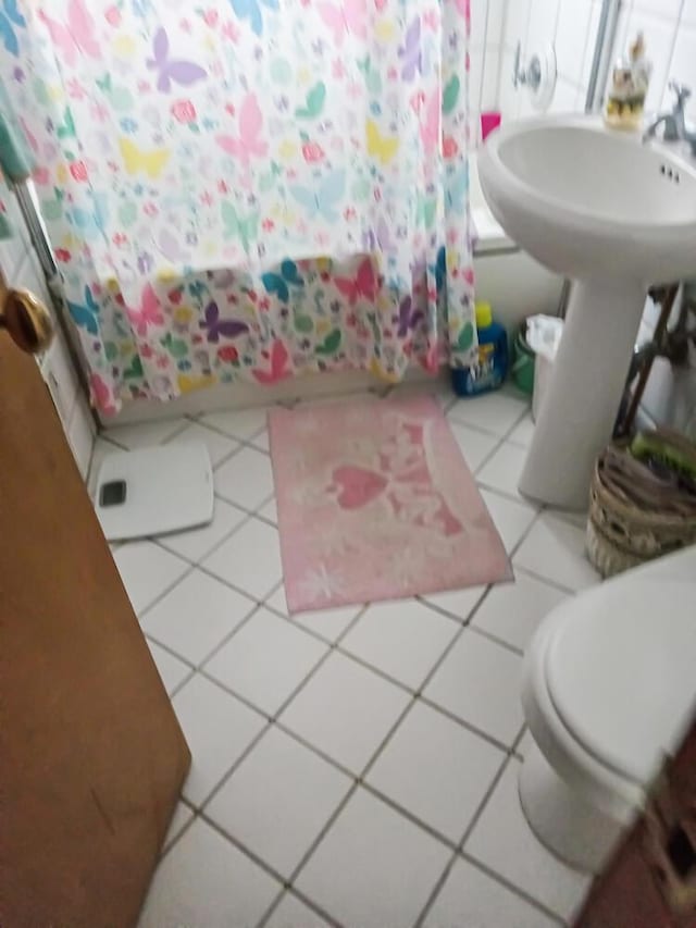 bathroom with tile patterned floors, toilet, and shower / bath combo