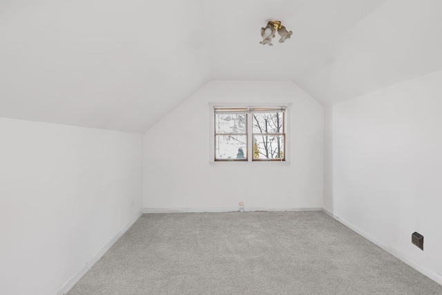 additional living space featuring lofted ceiling and light carpet