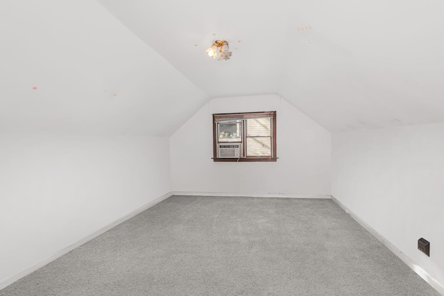 additional living space with light colored carpet and vaulted ceiling