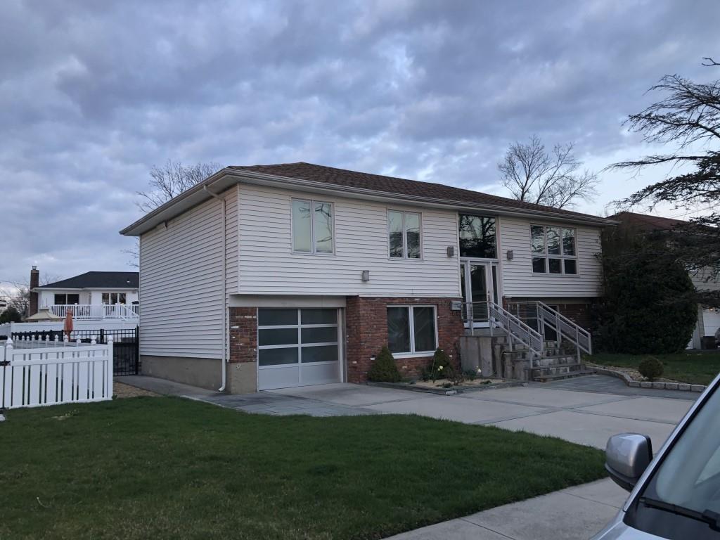 raised ranch featuring a garage and a front yard