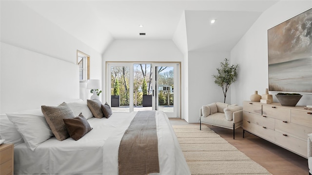 bedroom with light hardwood / wood-style floors, vaulted ceiling, and access to outside