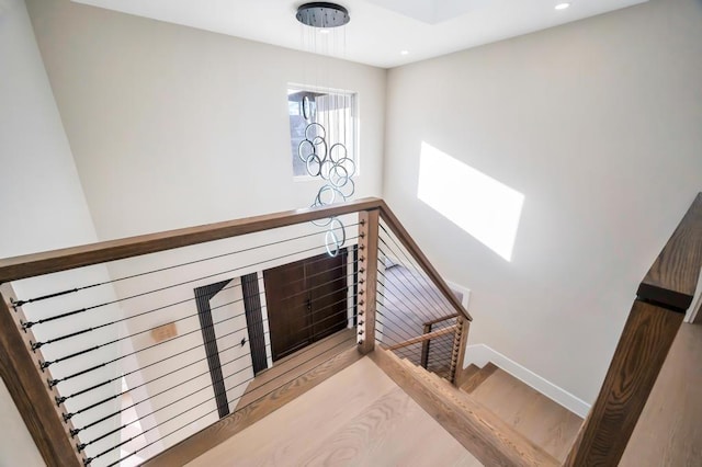 staircase with hardwood / wood-style flooring and a skylight