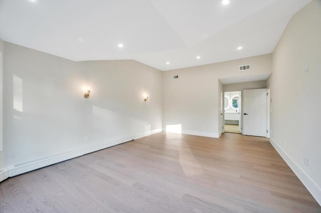 spare room with a baseboard radiator, lofted ceiling, and light hardwood / wood-style floors