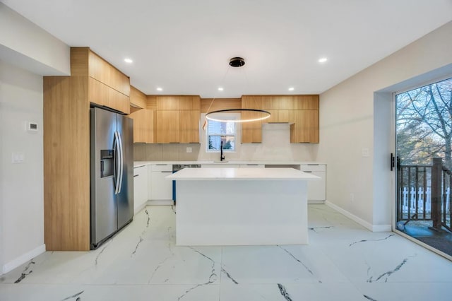 kitchen with stainless steel refrigerator with ice dispenser, sink, white cabinetry, a kitchen island, and backsplash