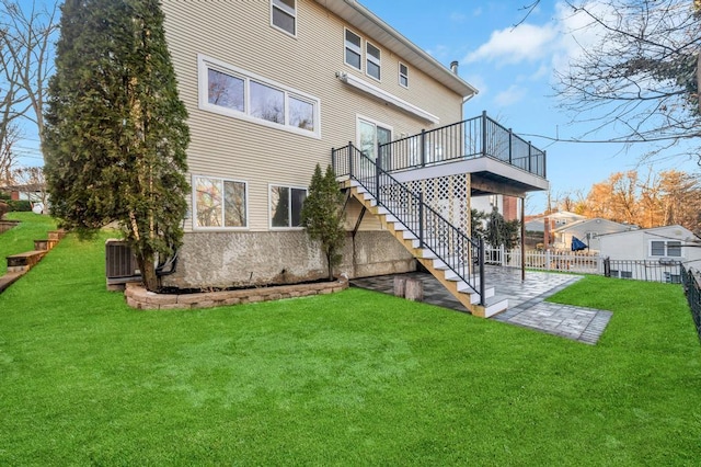 rear view of property with a yard, central AC, a patio area, and a deck