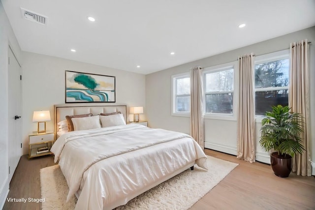 bedroom featuring multiple windows and light hardwood / wood-style flooring