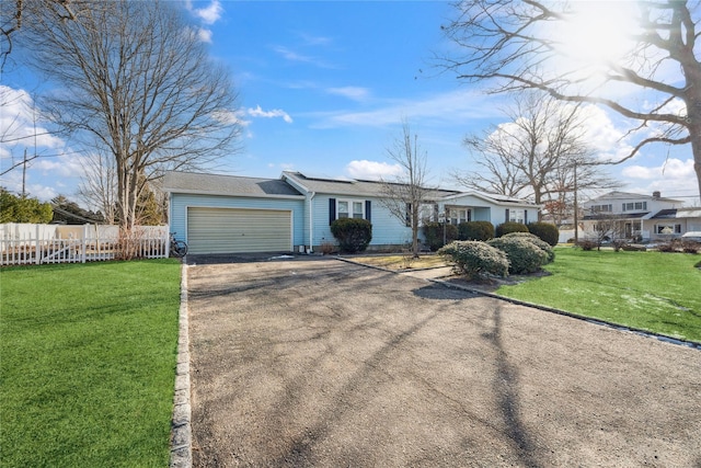 ranch-style house with a garage and a front lawn